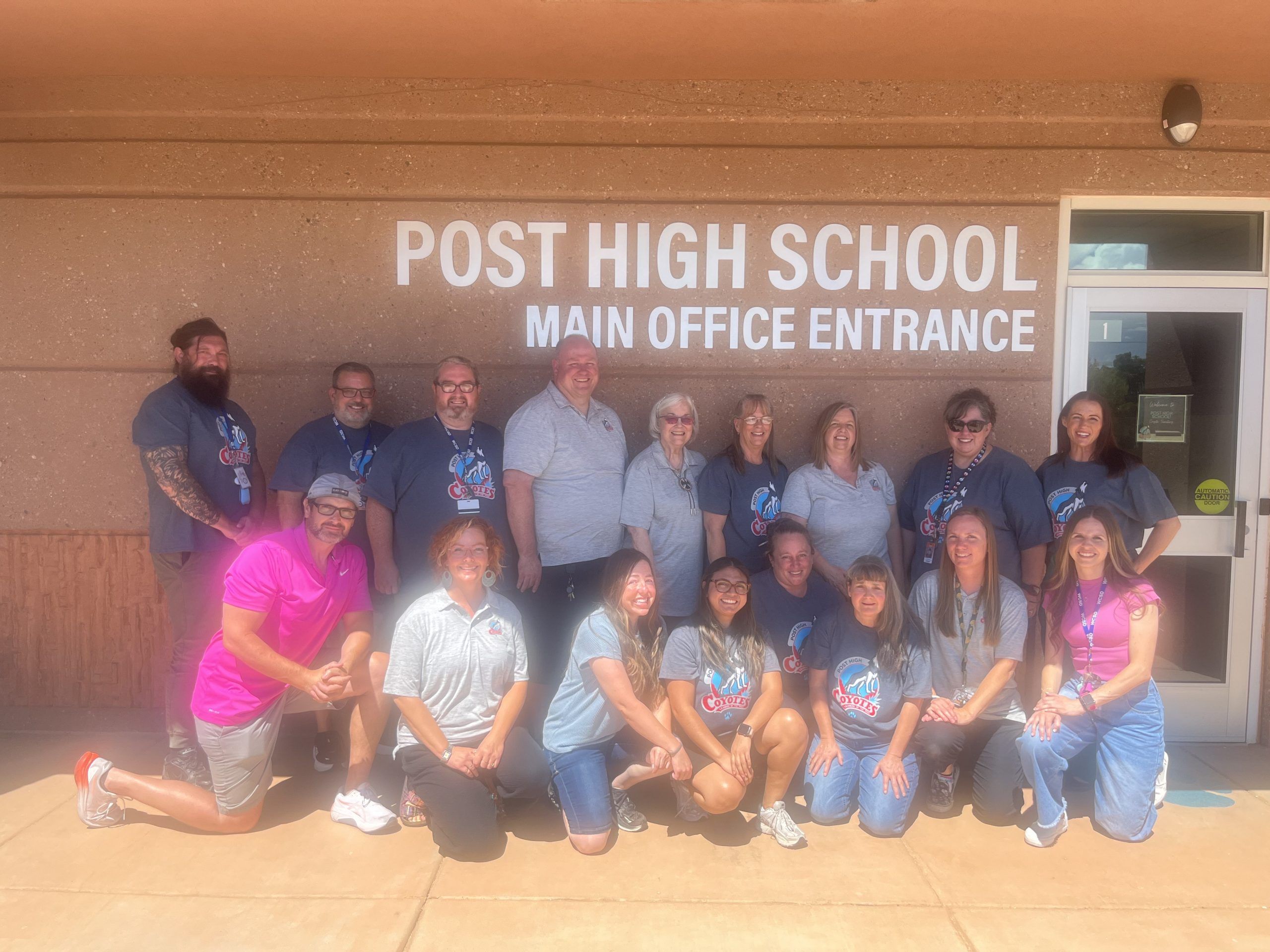 Team picture of post high school teachers and paraprofessionals outside of post high main entrance
