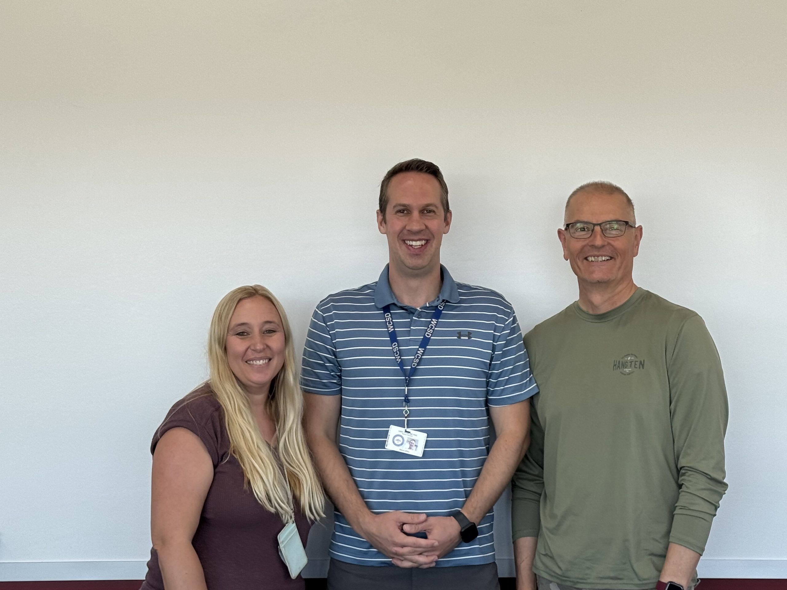 Team Picture of physical therapists in front of a wall in a school